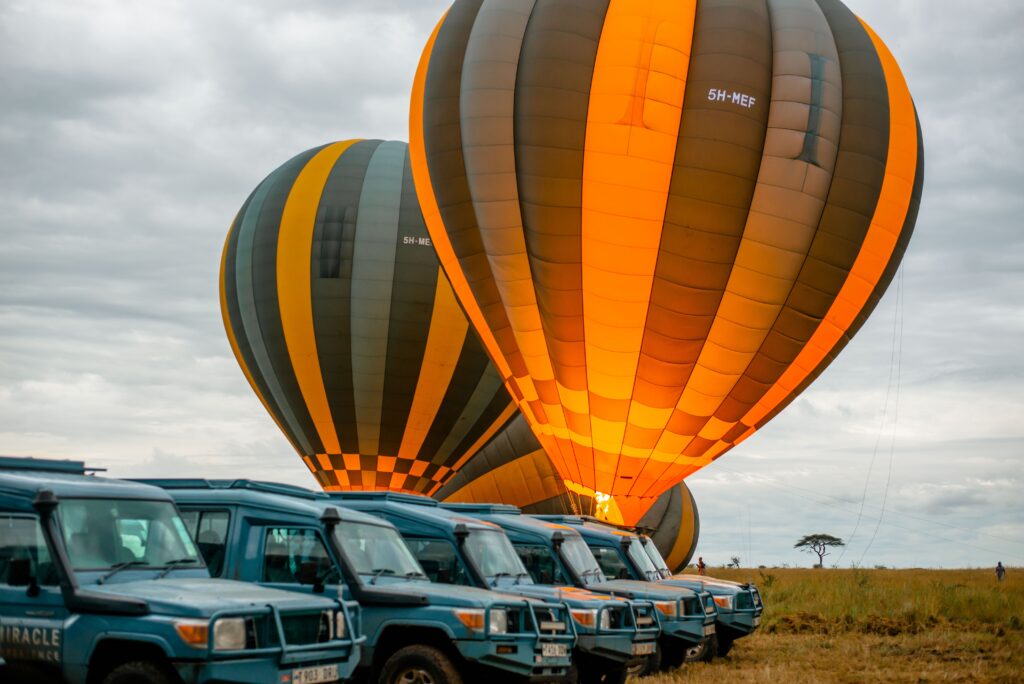 Safari vehicle types lined up in the Serengeti before a hot air balloon safari